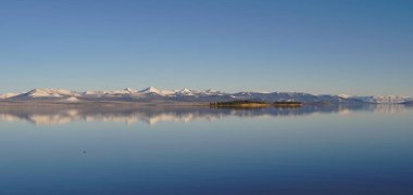 Yellowstone Gölü 'nün panoramik görüntüsü ve Absaroka Dağları mesafesi karla kaplıydı..