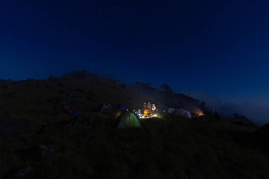 Mulayit Taung, Moei Wadi, Myanmar 'ın tepesinde gece ateşin etrafında çadır kuruyorlar..