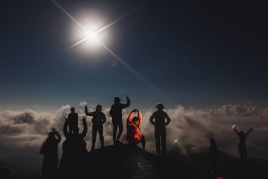 Mehtaplı gecede Mulayit Dağı manzarasını izlemek için ayakta duran insanlar. :