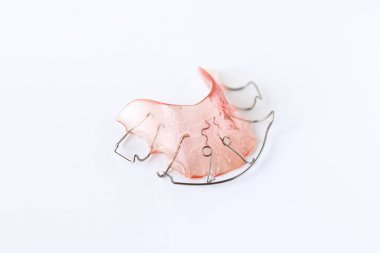 Pink retainers on white background. Retainers are important after braces. clipart