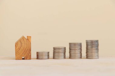 Çubuk grafiklerle düzenlenmiş bozuk paralarla ahşap ev. Ev konsepti almak için tasarruf.