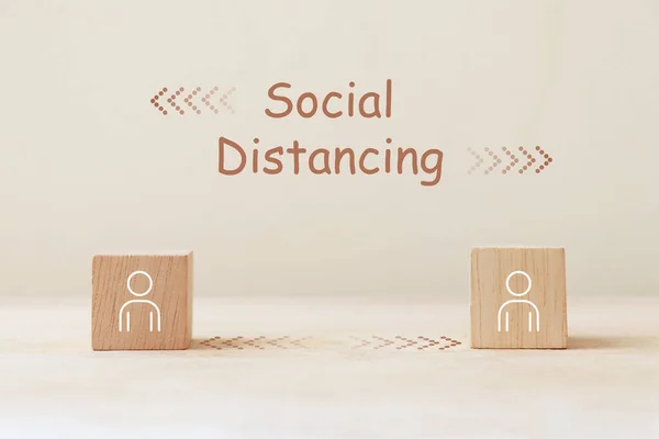 Social distancing for reducing the risk of infection. Person icon on wooden cube with social distancing concept.