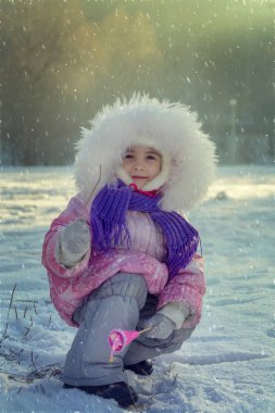 Kış manzarası. Yağan kar, güzel bir kızın önemsiz bir resmini çizer. Satın almak onu her zamankinden daha az memnun ediyor..