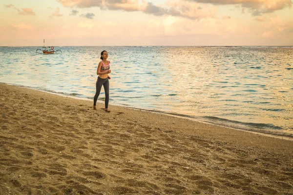 Frau joggt am Strand. Frau läuft barfuß bei Sonnenuntergang. Gesunder Lebensstil. — Stockfoto