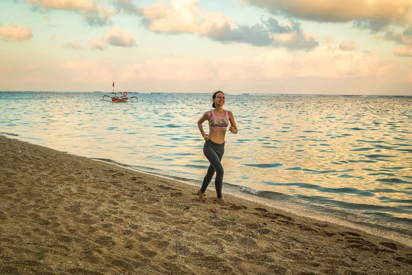 Mujer corriendo en la playa. Una mujer corriendo descalza al atardecer. Estilo de vida saludable. Indonesia, Bali, Pandawa beach . —  Fotos de Stock