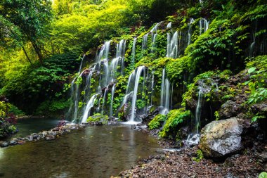 Şelale manzarası. Bali 'deki güzel, gizli Banyu Wana Amertha şelalesi. Wanagiri 'deki tropikal yağmur ormanlarında şelale. Yavaş deklanşör hızı, hareket fotoğrafçılığı.