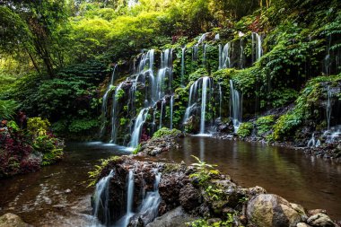 Şelale manzarası. Bali 'deki güzel, gizli Banyu Wana Amertha şelalesi. Wanagiri 'deki tropikal yağmur ormanlarında şelale. Yavaş deklanşör hızı, hareket fotoğrafçılığı.