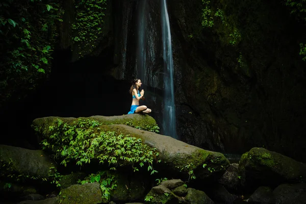 Mujer joven caucásica meditando, practicando yoga en cascada. Manos en namaste mudra. Leke Cascada de Leke, Bali, Indonesia . —  Fotos de Stock