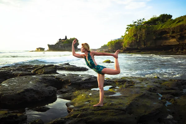 Outdoor sunset yoga. Attractive woman practicing yoga, standing in Natarajasana, Lord of the Dance Pose. Balancing, back bending asana. Bali, Indonesia — Zdjęcie stockowe