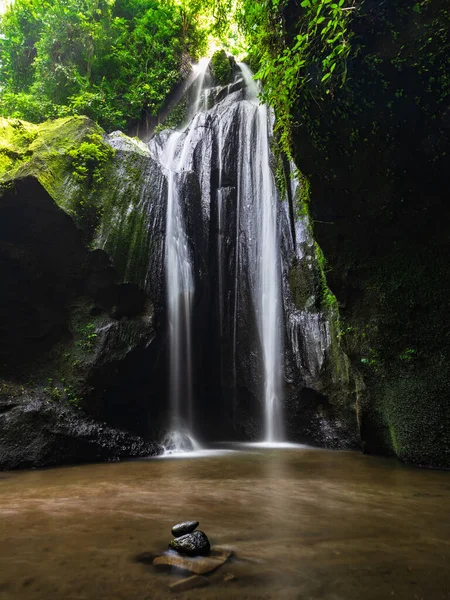 Tropical landscape. Waterfall in hidden canyon. Travel and adventure concept. Water flow. Soft focus. Slow shutter speed, motion photography. Landscape background. Krisik waterfall, Bangli, Bali