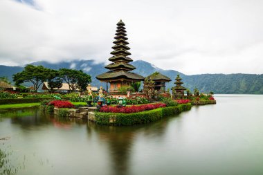 Bali adasındaki Pura Ulun Danu Bratan tapınağı. Güzel bale tapınağı. Bali 'nin simgesi. Yağmurlu, bulutlu ve sisli hava. Su yansıması. Kapama hızı yavaş. Bratan Gölü, Bali, Endonezya