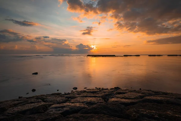 日出海景 令人惊讶的水反射 多云的天空 地平线上的阳光 多彩的日出用石头做的预测 让水面平静下来Nusa Dua海滩 印度尼西亚巴厘 — 图库照片