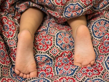 Ayakları halının üzerinde uyuyan bebek