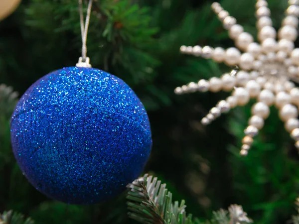 Boże Narodzenie Ciemnoniebieska Błyszcząca Piłka Wisząca Zielonej Gałęzi Drzewa Światła — Zdjęcie stockowe