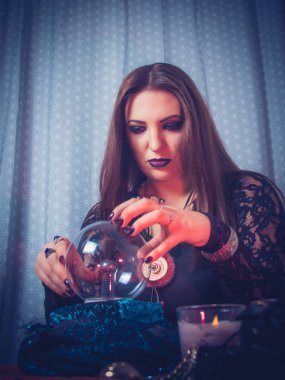 Bir falcı sihirli bir top, kart ve muska kullanarak geleceği tahmin eder. Tasarımcı için form. Büyü ve okültizm kavramı. Kehanet. fotoğraf modelleri