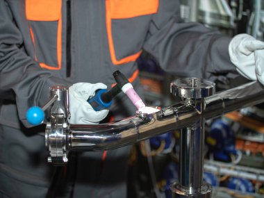 İşyerindeki kaynakçı. Kaynakçı boruyu argon ile kaynaklıyor. Kişisel koruyucu ekipman işçisi. Bölüm 1