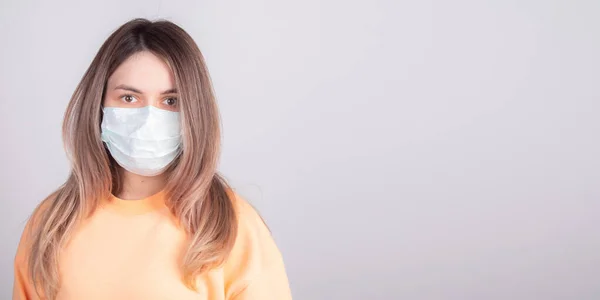 Yüzünde tıbbi maske olan perişan bir kız koronavirüs yüzünden uçuşunun iptal edilmesini bekliyor. pankart ettention covid-19