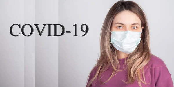 Yüzünde tıbbi maske olan perişan bir kız koronavirüs yüzünden uçuşunun iptal edilmesini bekliyor. pankart ettention covid-19