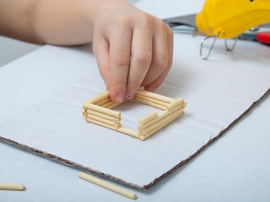 Bambu çubuklarından ev yapmak için adım adım talimatlar. Çocukların yaratıcılığı, el işi, online dersler. Adım 3: Evin gelecekteki kapıları ve pencereleri için açık yaratmak