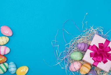 Mavi arka planda Paskalya yumurtası ve hediye.