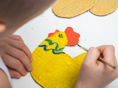 Kartondan yapılmış paskalya tavuğu. Kendi ellerinle. Çocuk el sanatları konsepti. Tavuğu Paskalya için renklerle süslüyoruz. Kendini tecrit sırasında el yapımı el sanatları..