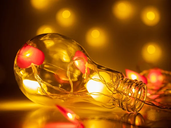 büyük dekoratif ampul ve kalp şeklinde ışıklar. Bokeh 'le fotoğraf. tebrik kartı