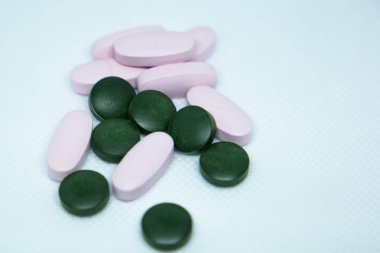 Beyaz arka planda pembe ve yeşil haplar