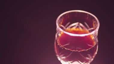 Siyah arka planda bir bardak kırmızı şarap.