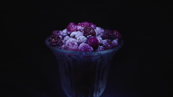 Gefrorene Himbeeren Einem Glas Auf Schwarzem Hintergrund Mit Farbtönen — Stockvideo