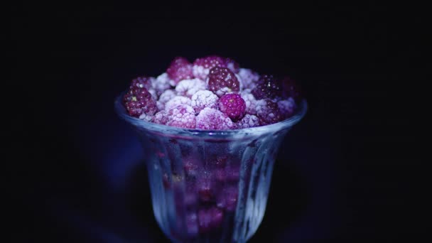 Gefrorene Himbeeren Einem Glas Auf Schwarzem Hintergrund Mit Farbtönen — Stockvideo