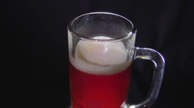 Siyah arka planda bir bardak soğuk bira.