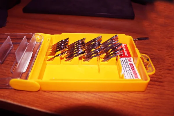 Sarı kutuya vida takın. Değişebilir tornavida seti farklı metal başlıklar ve ısırıklar. Metalden yapılmış aletler.