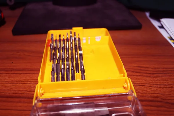 Sarı kutuya vida takın. Değişebilir tornavida seti farklı metal başlıklar ve ısırıklar. Metalden yapılmış aletler.