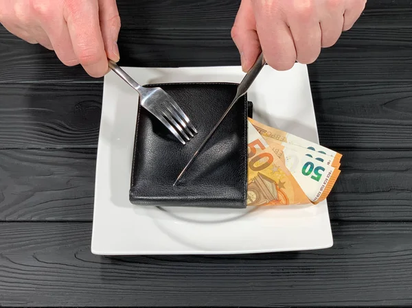 Bir adam bıçakla banknot kesiyor..