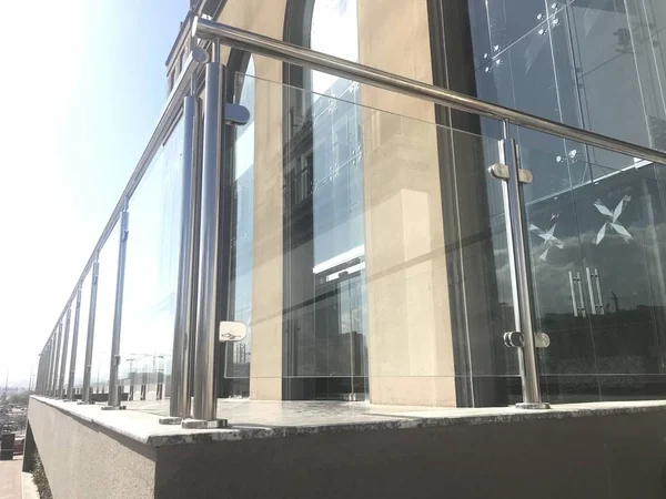 투명 한 스테인리스 유리로 만든 투명 한 난간 이 로비나 다중 층 건물 입구에 고정되어 있고 백운으로 보이는 하늘 배경 이 있다 — 스톡 사진
