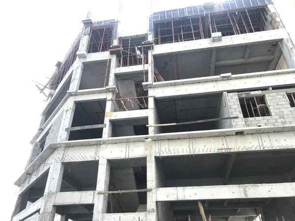 An Ongoing Construction Site front elevation view of Skeleton or Framed Structure consists of Columns Slab Beams and Shuttering work for slab in progress and workmen are working at various levels — Stock Photo, Image