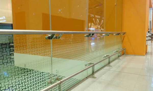 Vidrio templado Tabique de vidrio de altura completa junto con protección de pasamanos de acero inoxidable con paredes de fondo de color naranja — Foto de Stock