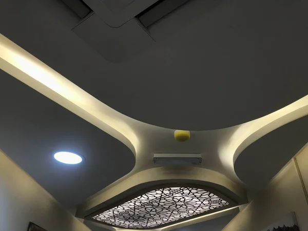 A Decorative Gypsum board suspended false ceiling with Coves for indirect lighting for an big hall area of an specialty hospital buildings interiors architectural work