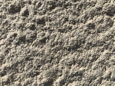 Yüzeyi sert ve atmosferik koşullar için birçok dalgalanma içeren yüksek binaların dış duvarına boyanmış ağır desenli bir taş dış görünüş.