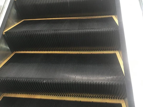 Μια μηχανική Escalators Σκάλα χάλυβα με κυματιστή τραχιά επιφάνεια για ένα εμπορικό κέντρο να φτάσει σε διαφορετικά επίπεδα και βαμμένα με μαύρο και κίτρινο σμάλτο χρώμα για καλύτερη ορατότητα — Φωτογραφία Αρχείου