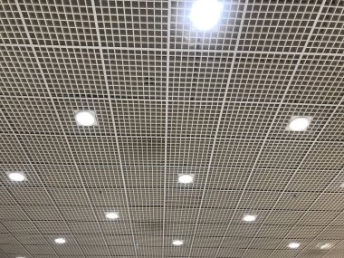 Beyaz askıya alınmış şebeke sahte tavan manzarası alışveriş merkezinin tavan dekorasyonunun ışıkları kapalı ve çift yükseklikte kapalı bir stadyum için kullanılabilir