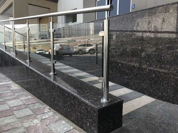 ステンレス製のクロムメッキ仕上げのハンドレールは 人々が落ちるのを避けるために より良い保護のための建物の内部のためのランプや階段の手順のためのガラスパネル — ストック写真