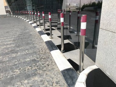 Alış veriş merkezinin girişindeki yol kenarındaki araçlardan korunmak için paslanmaz çelik krom kaplamalar.