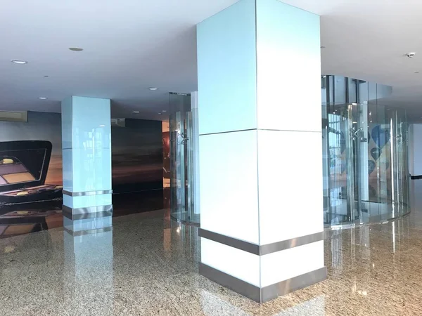 Şeffaf cam kaplamalı sütunlar ve paslanmaz çelikten etekler. Ticari bir bina için sahte tavan içleri.