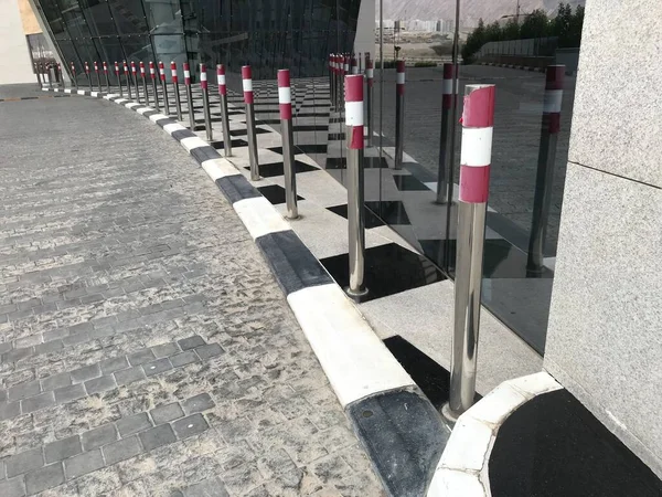 Alış veriş merkezinin girişindeki yol kenarındaki araçlardan korunmak için paslanmaz çelik krom kaplamalar.