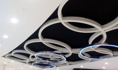 Kazançlı alçıtaşı sahte tavanı ve siyah arkaplan görünümlü ve beyaz akrilik emülsiyon boyalı dolaylı ışıklandırmalı farklı koylar tasarlıyor.