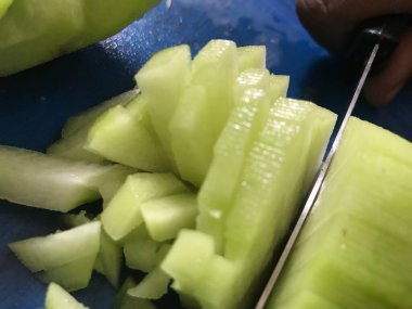 Mutfakta yemek pişirmek için sebze ve salatalık gibi armut şekilli su kabağı ailesi kesiliyor.