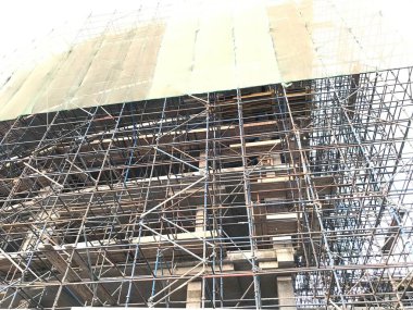 Bina inşaatı devam ediyor. Yüklenmiş vinç ve müşteriye ulaştırmak için somutlaştırma, güçlendirme ve iskele gibi faaliyetler kullanılıyor.