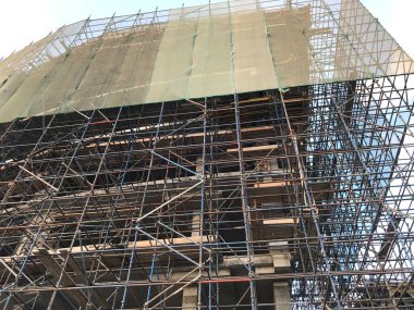 Bina inşaatı devam ediyor. Yüklenmiş vinç ve müşteriye ulaştırmak için somutlaştırma, güçlendirme ve iskele gibi faaliyetler kullanılıyor.