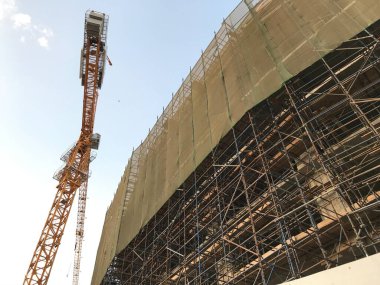 İnşaat projesi, vinç faaliyetlerinin kaldırılması ve bina çevresinde insan ve malzemelerin düşmesini önlemek için yeşil güvenlik ağı kurulmasıyla devam ediyor
